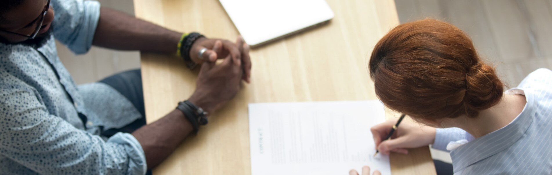 A woman sitting at a table filling out a form